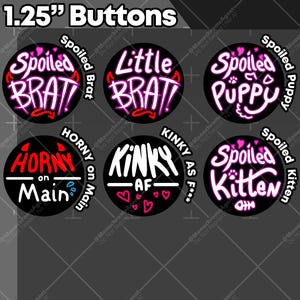 Könnte beinhalten: Sechs runde Knöpfe mit einem Durchmesser von ca. 3,2 cm. Die Knöpfe zeigen verschiedene Schriftzüge in Weiß und Pink auf schwarzem Hintergrund, darunter "Spoiled Brat", "Little Brat" und "Kinky AF".