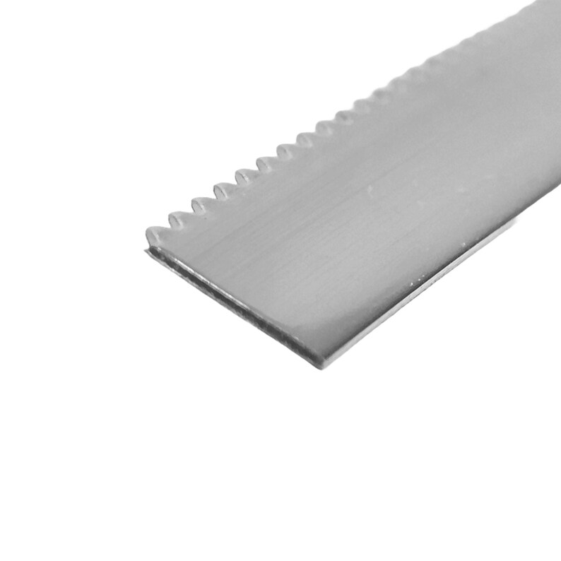 Op de afbeelding: Een close-up van een zilveren gekarteld metalen blad.