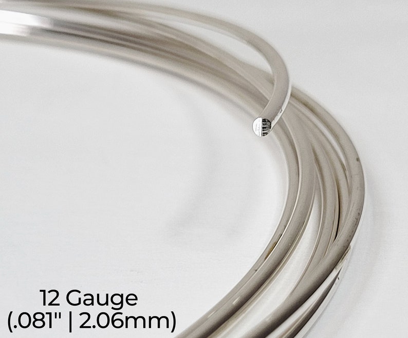 Pode incluir: Close-up de uma bobina de fio de prata, calibre 12, com 2,06 mm de di&acirc;metro. O fio &eacute; brilhante e liso.