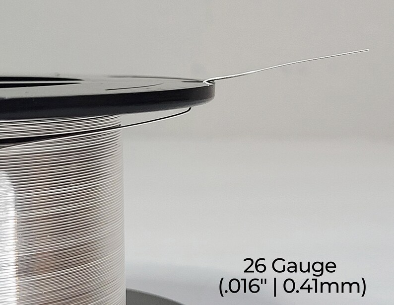 Pode incluir: Um carretel de fio prateado de calibre 26, com um di&acirc;metro de 0,41 mm.