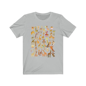Pu&ograve; includere: Una maglietta grigia chiaro con un motivo di molte giraffe diverse in varie pose. Le giraffe sono tutte di colori diversi e hanno diversi motivi sulle loro macchie.
