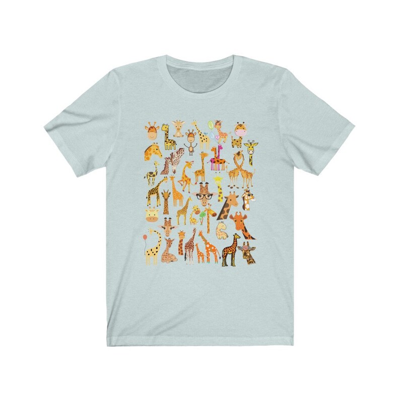 Pu&ograve; includere: Maglietta blu chiaro con un motivo di molte giraffe diverse in varie pose e colori. Le giraffe sono tutte in stile cartone animato e hanno espressioni diverse.