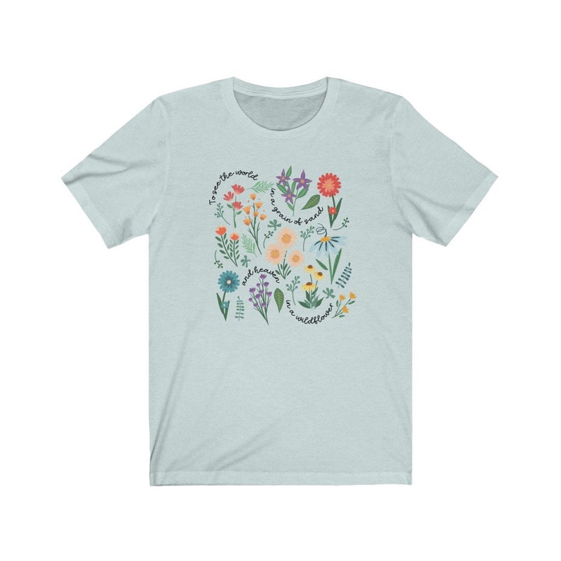 May include: Light blue t-shirt with a floral design and the text "To see the world as a grain of sand and heaven in a wildflower."