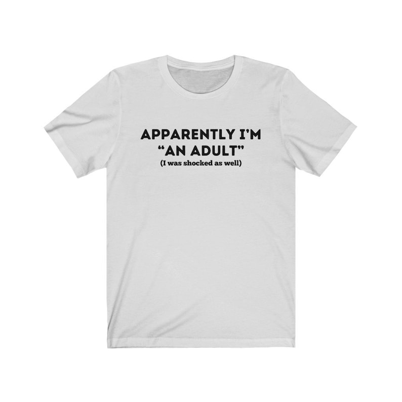 May include: White t-shirt with black text that reads "Apparently I'm "An Adult" (I was shocked as well)"