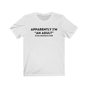 May include: White t-shirt with black text that reads "Apparently I'm "An Adult" (I was shocked as well)"