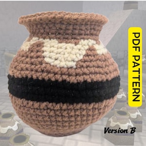 May include: A round, crocheted pot with a wide opening, featuring a brown base colour, a thick horizontal black band around the middle, and a cream-coloured geometric pattern near the top. The image includes the text PDF PATTERN and Version B.