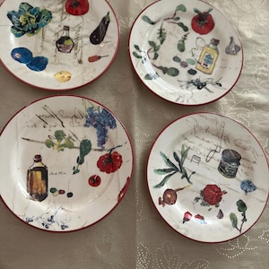 Pode incluir: Quatro pratos de cerâmica branca com bordas vermelhas, cada um decorado com ilustrações coloridas de vegetais, ervas e garrafas. Os pratos apresentam um estilo vintage pintado à mão, perfeito para decoração de cozinha.