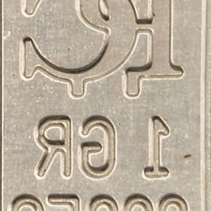 Op de afbeelding: Een zilveren staaf met een Bitcoin-symbool en de tekst "1 gr .9999 Fine" erop gegraveerd.