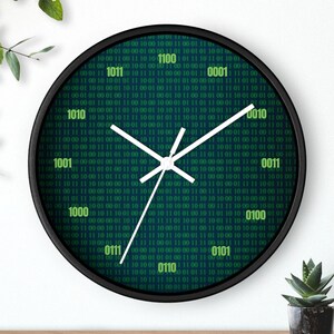 K&ouml;nnte beinhalten: Eine runde, schwarze Wanduhr mit einem gr&uuml;nen Bin&auml;rcode-Muster. Die Uhr hat wei&szlig;e Zeiger und zeigt die Zahlen 1000, 1001, 1010, 1011, 0100, 0101, 0110, 0111, 0001, 0010, 0011 und 1100 an.