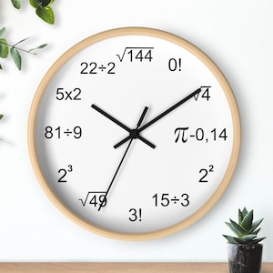 May include: A round wall clock with a light wood frame and a white face. The clock face features black numbers and mathematical symbols instead of traditional numbers. Black hour and minute hands indicate the time.