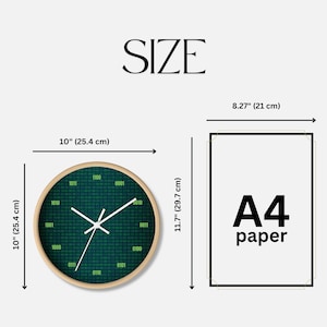K&ouml;nnte beinhalten: Eine runde Wanduhr mit Holzrahmen, 25,4 cm Durchmesser, mit dunkelgr&uuml;nem Zifferblatt mit Bin&auml;rcode und wei&szlig;en Zeigern. Daneben ein A4-Papier, 21 cm breit und 29,7 cm hoch.