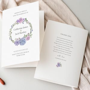 May include: Wedding ceremony order of service and thank you card with a floral design featuring purple and blue hydrangeas. The order of service card includes the names Catherine Jones and Jack Hartley, the date Saturday 20th March 2020, and the location Whittington Church, Worcester.