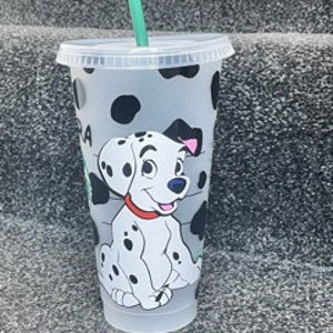 Puede incluir: Un vaso reutilizable de plástico transparente con un diseño de perro dálmata blanco y negro. El vaso tiene una pajita verde y una tapa negra.