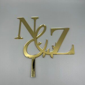 Custom monogrammed initials personalised gold acrylic cake topper with a stick