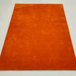 May include: A set of three ceramic mugs with a speckled, cream-colored glaze. Each mug features a different hand-painted floral design in shades of blue, green, and yellow. The mugs have a simple, modern shape.