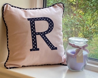 Cojín rosa personalizado, hecho a mano, con letras de lunares azul marino y blanco. Dos tamaños, 100 % algodón. Incluye funda y envío gratuito.