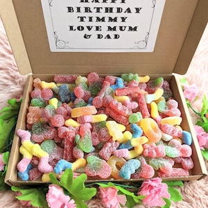 May include: A cardboard box filled with colourful gummy sweets. The box has a card on top that says "Happy Birthday Timmy Love Mum & Dad".