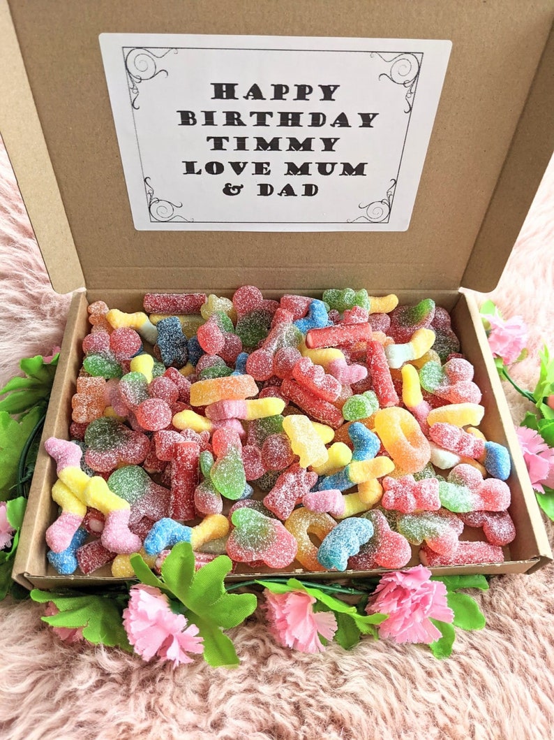 May include: A cardboard box filled with colourful gummy sweets. The box has a card on top that says "Happy Birthday Timmy Love Mum & Dad".