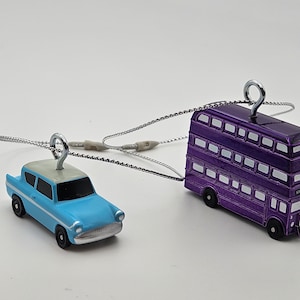 May include: A blue Ford Anglia car and a purple double-decker bus, both are miniature ornaments with silver chains attached to them. The bus has the words "Knight Bus" printed on the side.