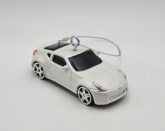 May include: White Nissan 370Z car ornament with a silver hook and string for hanging.
