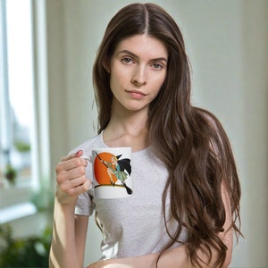 This ceramic coffee mug features a vintage deco illustration of a cute flapper witch flying on a broom with an orange full moon behind her.