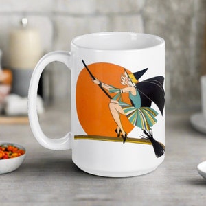 This ceramic coffee mug features a vintage deco illustration of a cute flapper witch flying on a broom with an orange full moon behind her.