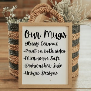 May include: A framed sign with the text "Our Mugs" in black cursive font. The sign lists the features of the mugs: "glossy ceramic", "print on both sides", "microwave safe", "dishwasher safe", and "unique designs".
