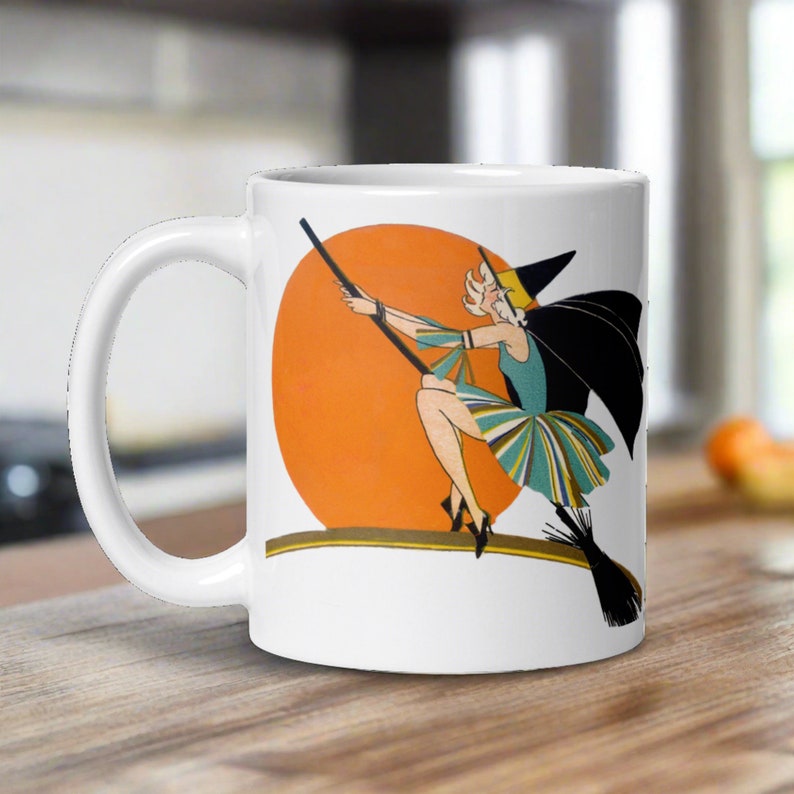 This ceramic coffee mug features a vintage deco illustration of a cute flapper witch flying on a broom with an orange full moon behind her.