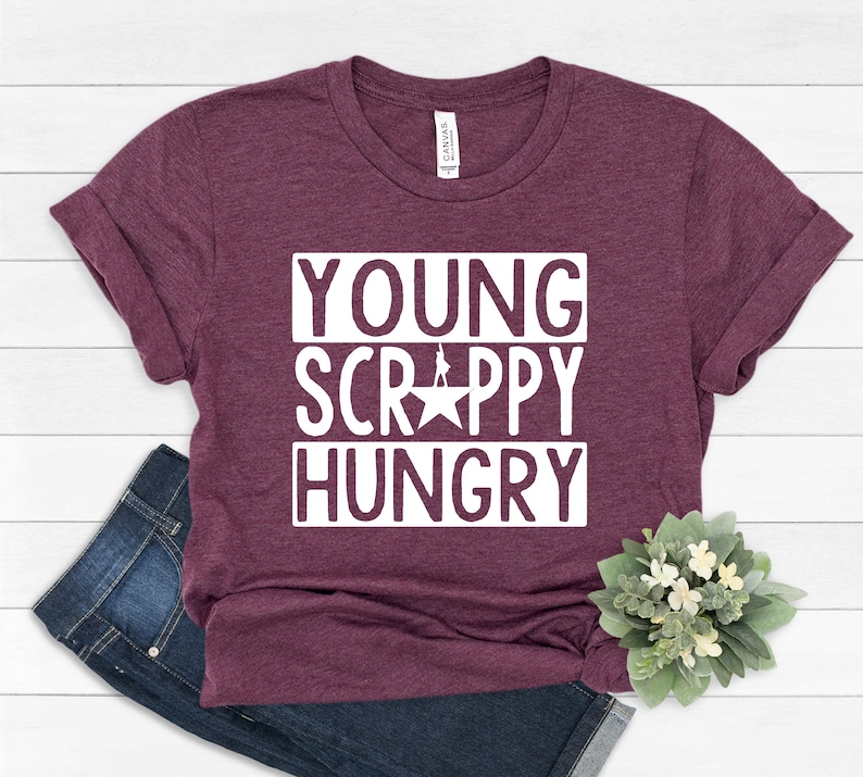 May include: A maroon t-shirt with the text "YOUNG SCRAPPY HUNGRY" in white letters. The text is in a bold, blocky font.