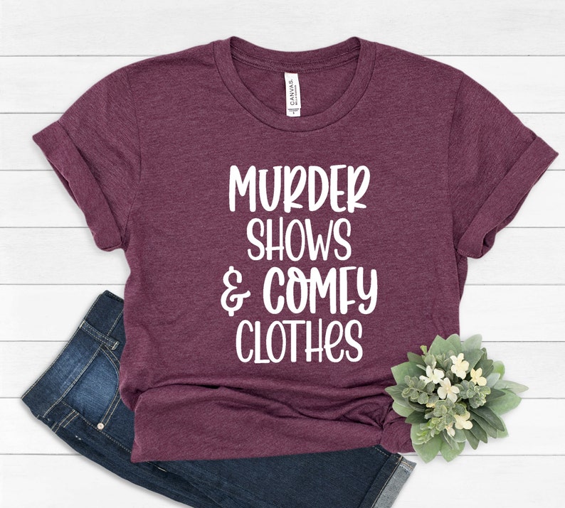 May include: Burgundy t-shirt with white text that reads "Murder Shows & Comfy Clothes".