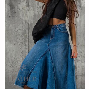 May include: A blue denim skirt with a flared hem and a raw edge. The skirt has a high waist and a button closure.