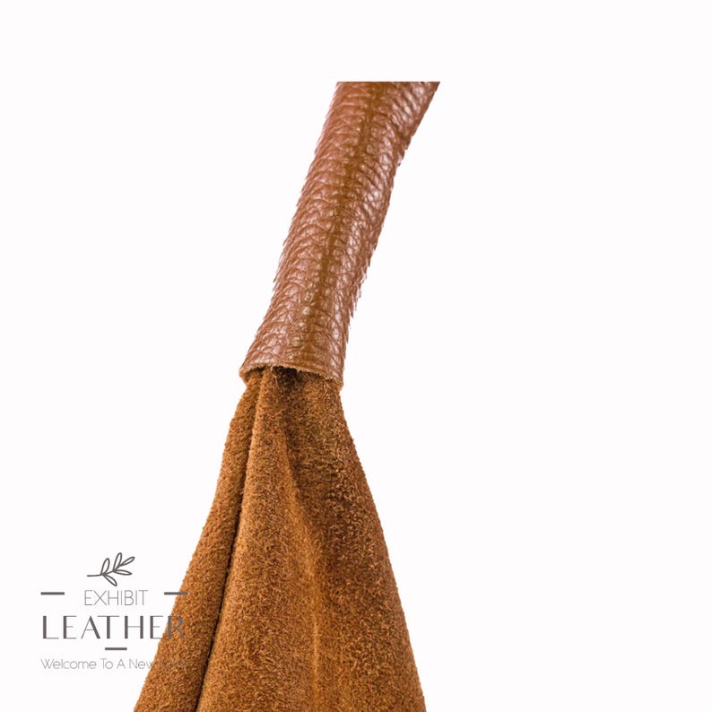 May include: Close-up of a brown leather handbag with a suede body and a brown leather handle.