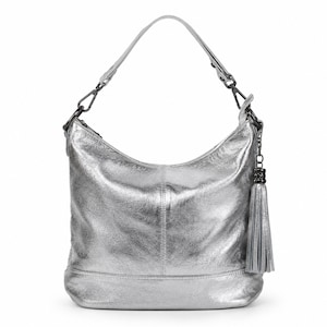 Könnte beinhalten: Silberfarbene Hobo-Tasche mit einem einzelnen Schulterriemen und einem dekorativen Quastenanhänger. Die Tasche hat eine geschwungene Oberseite und einen flachen Boden. Die Hardware ist dunkelgrau. Die Tasche besteht aus einem glänzenden, strukturierten Material.