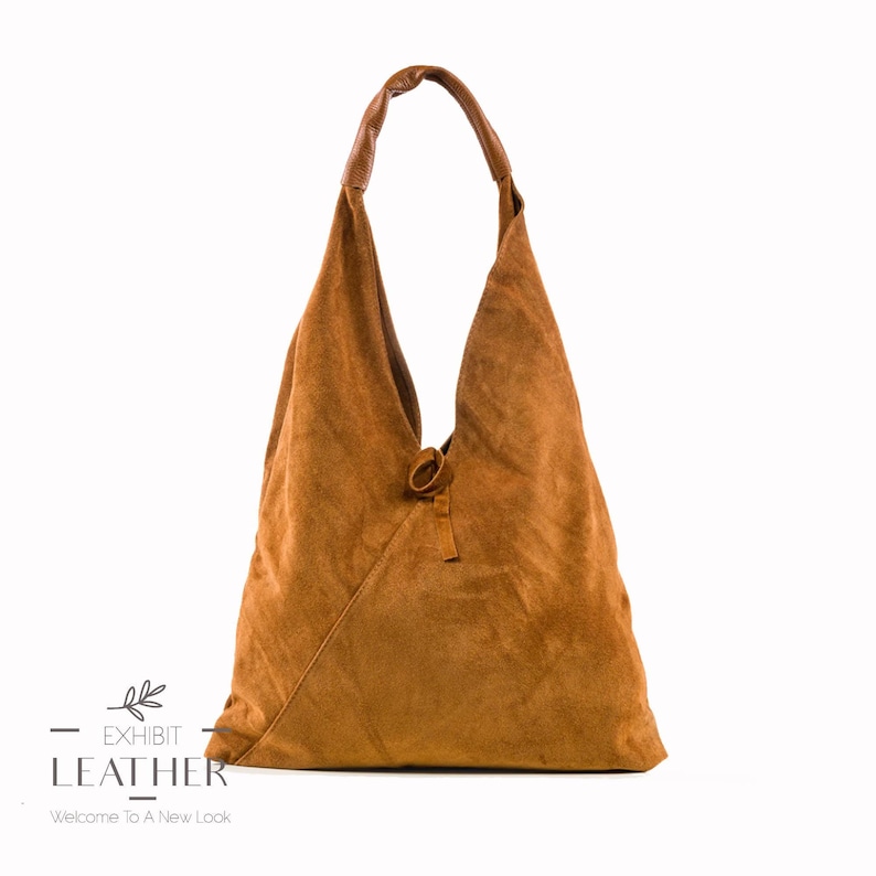 May include: A brown suede hobo bag with a knotted strap. The bag has a triangular shape and is made of soft, supple leather.