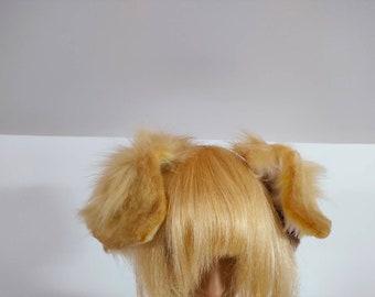 Könnte beinhalten: Ein Paar hellbraune, flauschige Tierohren an einem Haarreifen, getragen über einer blonden Perücke mit geradem Pony. Die Ohren bestehen aus weichem, strukturiertem Kunstfell und sind seitlich am Kopf angebracht, um ein hundeartiges Aussehen zu erzeugen.