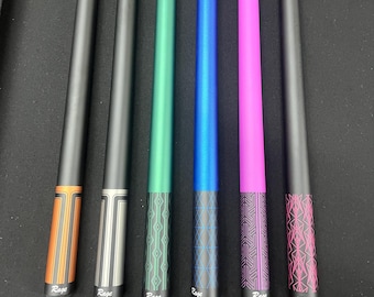 May include: Six pool cues with black shafts and various colored accents. The cues feature orange, silver, green, blue, pink, and black designs. Each cue has the word "Rage" printed on it, with the exception of one that has "2212".