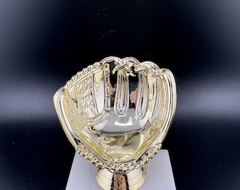 May include: A gold-colored baseball glove trophy on a white marble base. The trophy has a detailed design of a baseball glove and a gold-colored stem. The base has a gold plate with the text "Your Engraving Goes Here".