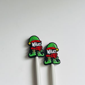 May include: Two white pens with green and red elf toppers that say "What the Elf?"