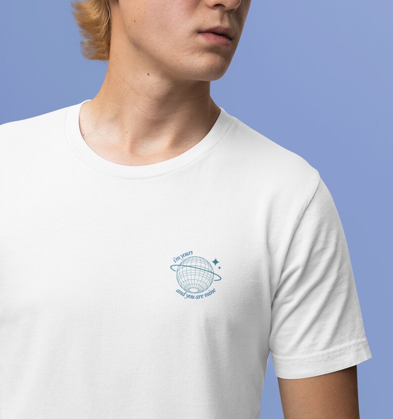 May include: White t-shirt with a blue graphic of a globe with a ring around it and stars. The text "I'm yours and you are mine" is written on the graphic.
