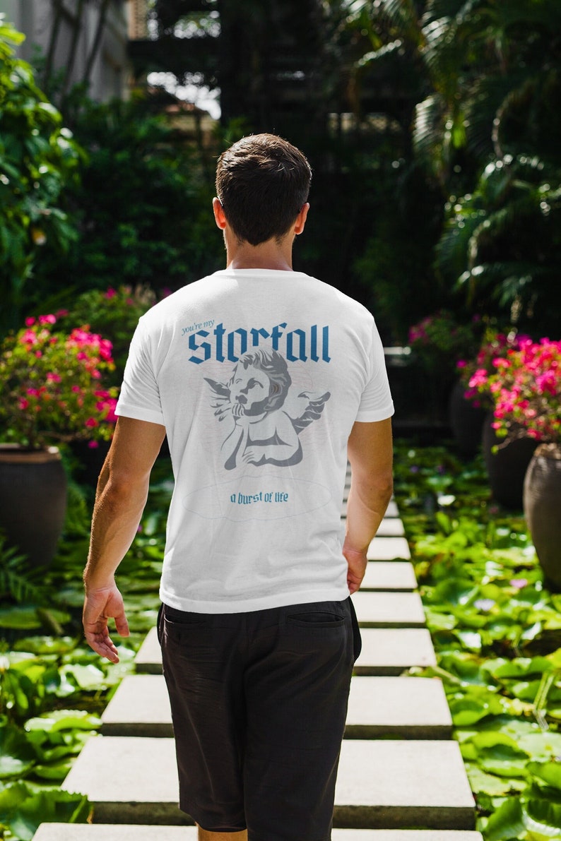 May include: A white t-shirt with a graphic of a cherub with wings and the text "You're my Starfall, a burst of life".