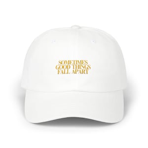 May include: White baseball cap with gold embroidered text that reads "Sometimes good things fall apart".