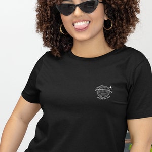 May include: A black t-shirt with a white graphic of a globe with the text "The world is yours and you are here".