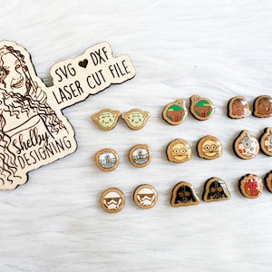 May include: A collection of wooden laser cut files depicting Star Wars characters such as Yoda, Boba Fett, and Darth Vader. The set includes a wooden cutout with the text "SVG DXF LASER CUT FILE" and a portrait of a woman.