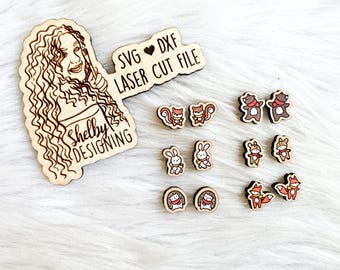May include: A wooden sign with the text "SVG ♥ DXF LASER CUT FILE" and the words "Shelby Designing" on a brown background. The sign is surrounded by small wooden cutouts of animals, including bears, squirrels, bunnies, and foxes.