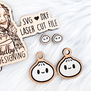 May include: A set of laser cut wooden SVG and DXF files for creating cute, cartoon-style dumpling earrings. The files are designed by Shelby Designing and include a small heart symbol.