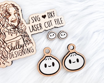 Könnte beinhalten: Ein Satz aus lasergeschnittenen Holz-SVG- und DXF-Dateien zum Erstellen von niedlichen, cartoonartigen Dumpling-Ohrringen. Die Dateien wurden von Shelby Designing entworfen und enthalten ein kleines Herzsymbol.