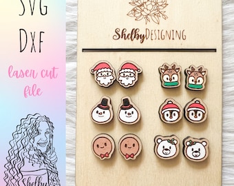 May include: A wooden display board with eight pairs of laser cut wooden Christmas earrings. The earrings feature Santa, reindeer, snowmen, gingerbread people, and polar bears. The board has the text "ShelbyDESIGNING" on it.
