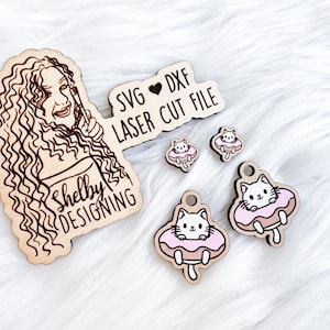 May include: A set of laser cut wood earrings featuring a donut with a cat inside. The earrings are packaged with a wood sign that says "Shelby Designing" and a separate wood sign that says "SVG ♥ DXF LASER CUT FILE".