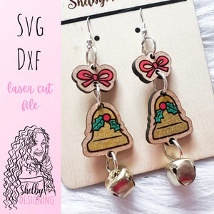 Może przedstawiać: Para kolczyków w kształcie złotych i czerwonych dzwonków świątecznych z kokardką i zawieszką w kształcie dzwonka. Plik do cięcia laserowego SVG i DXF.