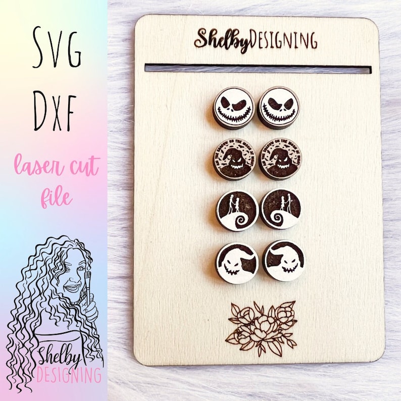 May include: A set of six laser cut wooden earrings featuring characters from the Nightmare Before Christmas. The earrings are in the shape of circles and feature various characters from the movie, including Jack Skellington, Sally, and Zero. The earrings are on a wooden display board with the text "Shelby DESIGNING" at the top.